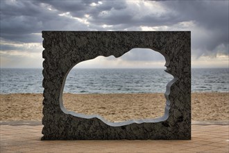 Sculpture in stone with breakthrough in the shape of the island of Foehr and view of the North Sea