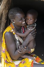 Woman with her baby sitting in a hut