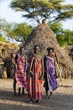 Older women from the Toposa tribe before their traditional hut