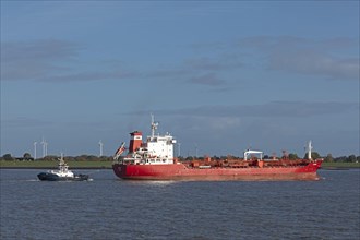 Tugboat guiding cargo ship