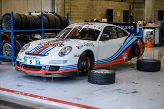 Porsche 911 GT3 in pitbox changing tyres to rain tyres on trackday