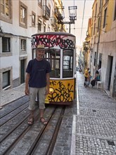Man standing on rails in front of funicular