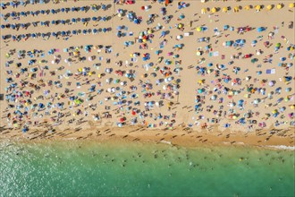 Drone shot of people enjoying the beach and the ocean