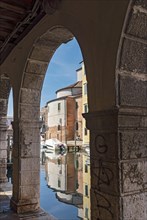 Canal Vena seen throuh arcade of Palazzo Grassi