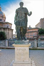 Life-size statue of Julius Caesar on marble plinth next to Forum of Caesar