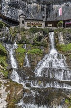 Ensemble of buildings with waterfall in front of the Saint Beatus Caves
