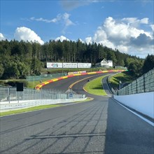 View from a moving race car onto the Eau Rouge bend and Raidillon slip road of the Circuit de Spa-Francorchamps