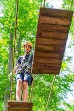 Boy climbing in the climbing forest and high ropes course