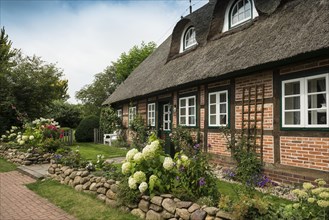 Thatched half-timbered house and summer garden