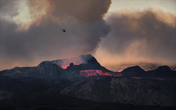 Helicopter flying over nus erupting volcano with lava fountains and lava field