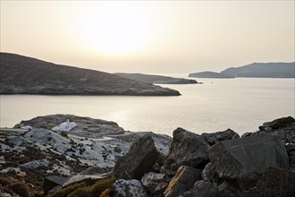 Coast of Tinos at the narrowest point to Andros in the unusual white sunset light