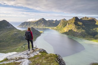 Hiker looks from the mountain Kollfjellet to the fjord and mountains of Lofoten