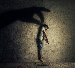 Human hand shadow holding a powerless man hanging