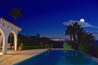 Villa with pool at night with full moon
