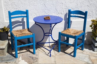 Blue chairs and a table outside a cafe in Myrtos