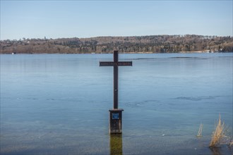 Winter memorial cross in the icy water at the spot in the shallow shore area of Lake Starnberg where King Ludwig II of Bavaria was found dead in 1886
