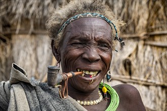 Old woman of the Jiye tribe smoking a pipe