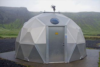 Futuristic igloo-shaped building in rugged landscape