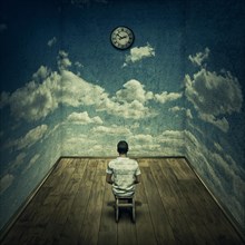 Abstract idea with a person sitting in a dark room in front of a clock surrounded by limitations daily routine concrete walls with clouds texture