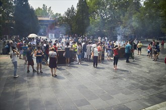 Tourists with incense sticks at the Lama Temple