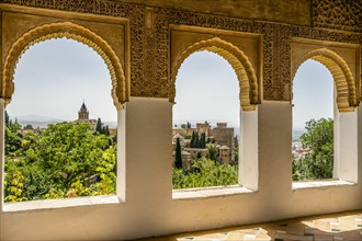 View of Nasrid Palaces through arches of Generalife Palace in Alhambra in Granada