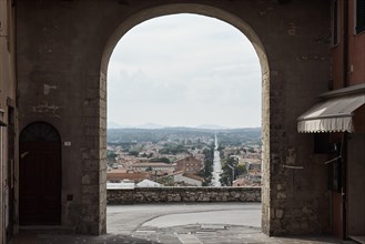Gate of the city wall of the old town of Castiglione del Lago with view of the new town