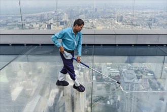 Man cleaning glass floor Maha Nakhon Tower
