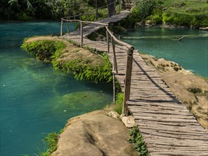 Wooden bridge crossing the turquoise water of the Minas viejas waterfalls