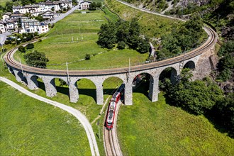 Aerial of a Train crossing the Brusio spiral viaduct