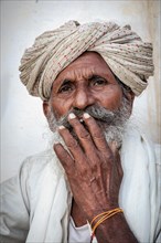 Elderly Indian man resting on a bed