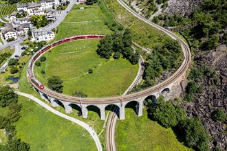 Aerial of a Train crossing the Brusio spiral viaduct