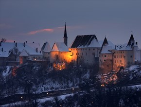 Illuminated castle complex with chapel in winter