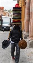 Souvenir seller with many hats on his head