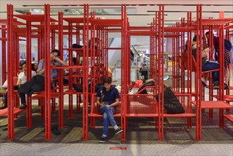 Red iron rack with seating and lounging area for customers to rest