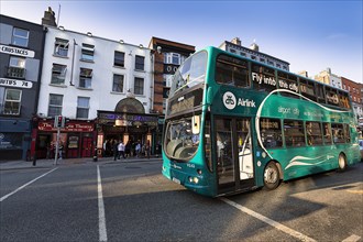 Green double-decker bus Airlink Express travels from the airport to the city centre