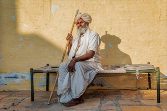 Elderly Indian man resting on a bed