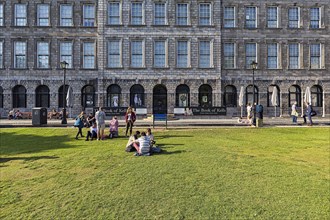 Students on a lawn in front of the library of Trinity College