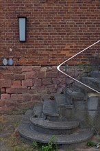 Stairs with railing in front of red brick wall