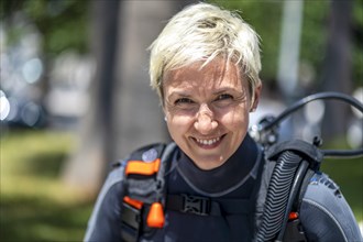 Portrait of a happy scuba diver with an oxygen tank and wet suit already on