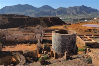 Mine ruins with washbasin against a mountainous backdrop