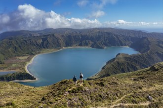 Hikers at the summit of Pico Barrosa with view to the crater lake Lagoa do Fogo