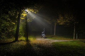 A person rides a bicycle through a lonely park in Markt Swabia