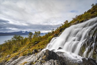 Waterfall with view of lake Akkajaure and mountain range Akka