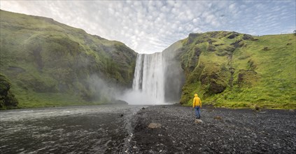 Huge waterfall behind a person