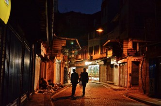 Two men on street in old town Eminoenue at night
