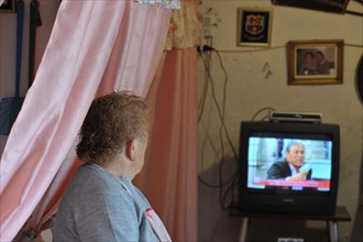Old woman from behind watching TV