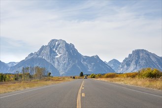 Country road in front of Grand Teton Range mountain