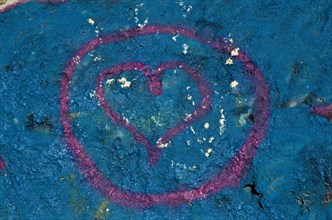 Painted heart as @ symbol painted on blue wall
