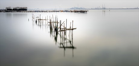 Long-term photograph of piles with fishing nets in front of the lagoon city