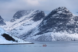 Fishing boat in winter Scandinavian landscape at the fjord